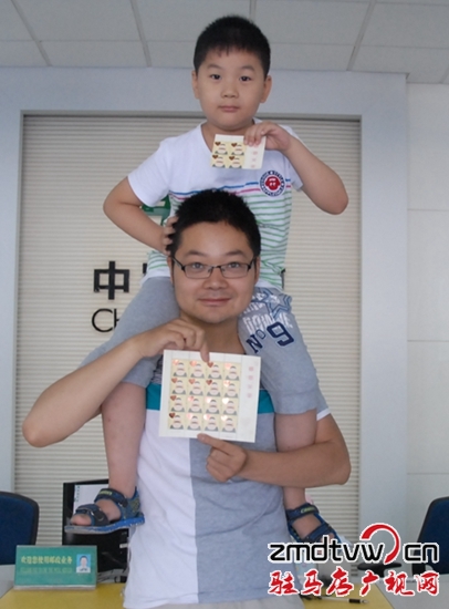 圖為6月13日，一對(duì)父子在市中心郵政所展示“感恩父親”特種郵票 .JPG