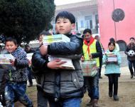 2016年1月8日下午,在駐馬店市汝南縣三門閘街道大新莊小學(xué)校院內(nèi)，駐馬店市陽光助學(xué)協(xié)會負責(zé)人及志愿者、大新莊學(xué)校師生、學(xué)生家長歡聚一堂，舉行了“陽光助學(xué)愛心圖書室”捐贈儀式。圖為學(xué)生和志愿者一起搬運新書