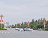 駐馬店市開源大道，道路兩旁清一色的紅旗在迎風(fēng)飄揚(yáng)。所有紅旗都是在燈桿的一側(cè)逆時(shí)針旋轉(zhuǎn)90°豎著懸掛，鮮艷的國(guó)旗整齊地朝向一側(cè)，非常壯觀。