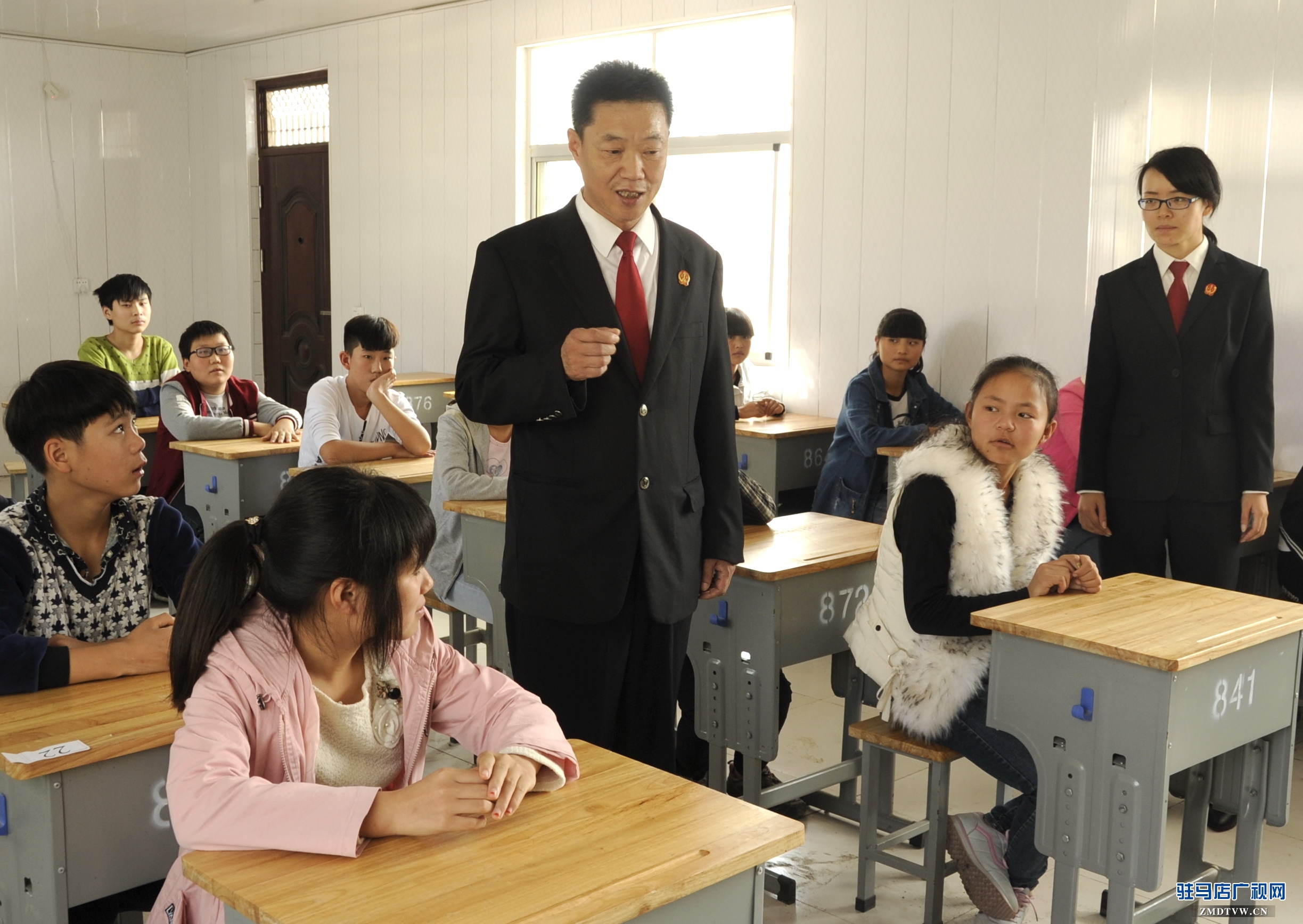 【04】泌陽(yáng)縣人民法院少年家事綜合審判庭的杜偉法官，正在向“旁聽(tīng)席”上的初中學(xué)生們講解法律知識(shí) (1).jpg