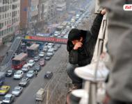 圖為2014年1月3日，蘭州，6名農(nóng)民工為了討薪爬上白銀路一居民樓9樓平臺(tái)要“跳樓”。原來，該樓4層的甘肅天安建筑機(jī)械工程公司拖欠24名工人的24萬元工錢，他們討要5個(gè)月毫無結(jié)果，便做出危險(xiǎn)之舉。后經(jīng)有關(guān)部門多方協(xié)調(diào)，工人們當(dāng)場(chǎng)拿到了18萬元。于永昭/視覺中國(guó)