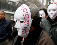 近幾年，由于經(jīng)濟(jì)增速下行，中西部地區(qū)和中小城市成為當(dāng)前討薪矛盾多發(fā)地區(qū)。一邊是國(guó)家和地方維護(hù)打工者權(quán)益的法律法規(guī)不斷出臺(tái)，另一邊則是“年年干活年年欠，年年討薪年年難”。不少打工者不得已只好采取行為藝術(shù)等手段以博取關(guān)注。圖為2015年2月2日，西安市尚德路陜西省水利廳的門前，七八位頭戴著白色面具者站在凜凜寒風(fēng)中，面具上寫著：“含淚討工錢” “無顏見父母”等標(biāo)語。據(jù)了解，這幾個(gè)人是70名農(nóng)民工的代表，他們之前在武功縣干的工程被欠款156萬元。誰知，包工頭不但電話打不通，以前的家也搬了，根本找不到人，多次找到水