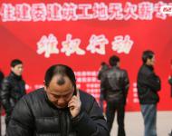 2013年1月27日，寧波市住建委“建筑工地?zé)o欠薪專項(xiàng)維權(quán)行動(dòng)”在寧波書城外廣場(chǎng)舉行，20余家大型建筑企業(yè)負(fù)責(zé)人現(xiàn)場(chǎng)辦公，對(duì)討薪工人涉及的問題現(xiàn)場(chǎng)進(jìn)行解答，確保工人及時(shí)拿到工錢，開心回家過春節(jié)。圖為一位工人在打電話。張培堅(jiān)/視覺中國(guó)