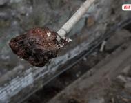在遷安市中化煤化工有限責任公司的圍墻外是污水排放溝，溝里的泥成為紅褐色。