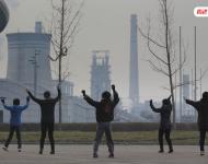 圖為耗資13億建成的邯鄲武安市體育館外，本地的不少中年婦女，每天會在固定時間來到這里：她們背對體育館，面向文安鋼鐵廠，跳起了廣場舞。邯鄲武安市區(qū)有十幾個鋼鐵廠、電廠、焦化廠包圍，不管刮什么風，城區(qū)污染都很嚴重。視覺中國