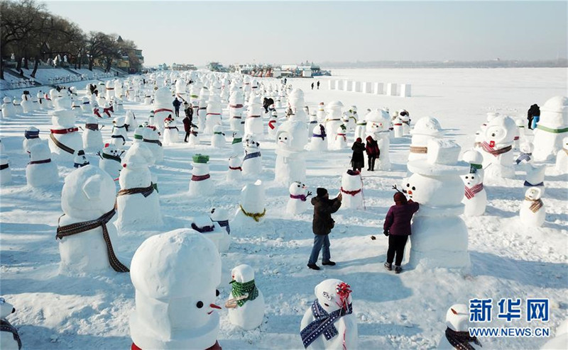 1月2日，市民、游客在雪人群中游玩觀賞（無(wú)人機(jī)拍攝）。2019個(gè)各式各樣的雪人，近日在冰城哈爾濱市的松花江畔亮相，引來(lái)眾多市民游客游玩觀賞。新華社記者 王建威 攝